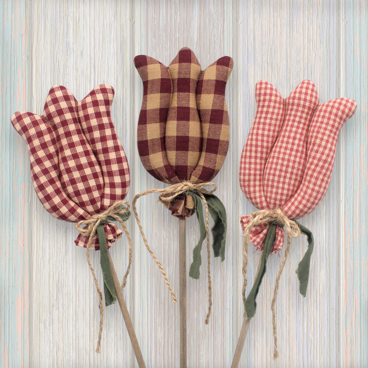 Three checkered tulip decorations on sticks against a striped background