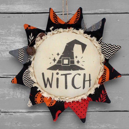 Primitive handmade fabric sunflower ornament for Halloween with a printed center with an image of a witch hat 
