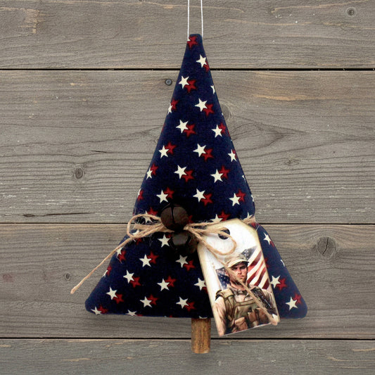 Handmade tree-shaped Christmas ornament made from fabric with stars on a dark blue background, decorated with rusty bells and a tag.