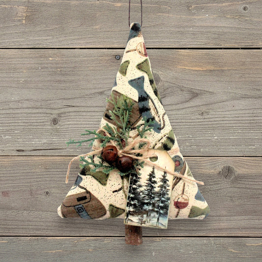 Handmade fabric tree-shaped Christmas ornament with fish and fishing gear on a tan background, decorated with rusty bells, pine and a tag