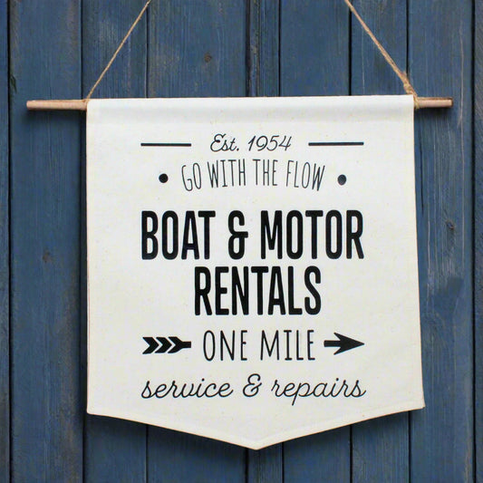 Canvas banner with text about boat and motor rentals on a wooden background