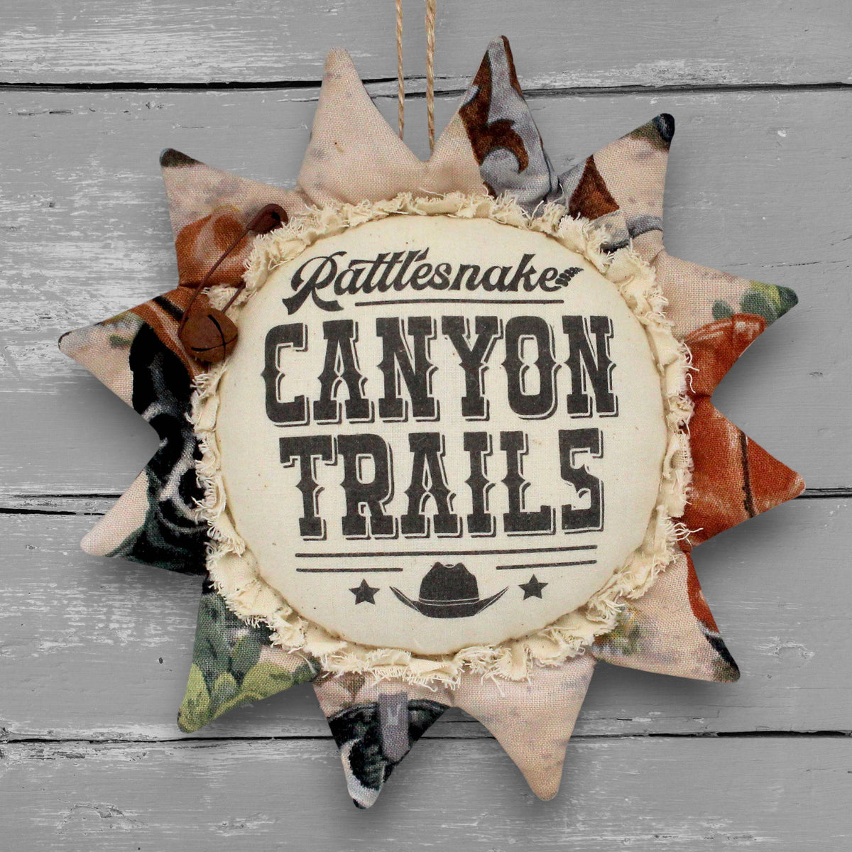 Handmade primitive fabric sunflower ornament with a printed center that advertises for Rattlesnake Canyon Trails