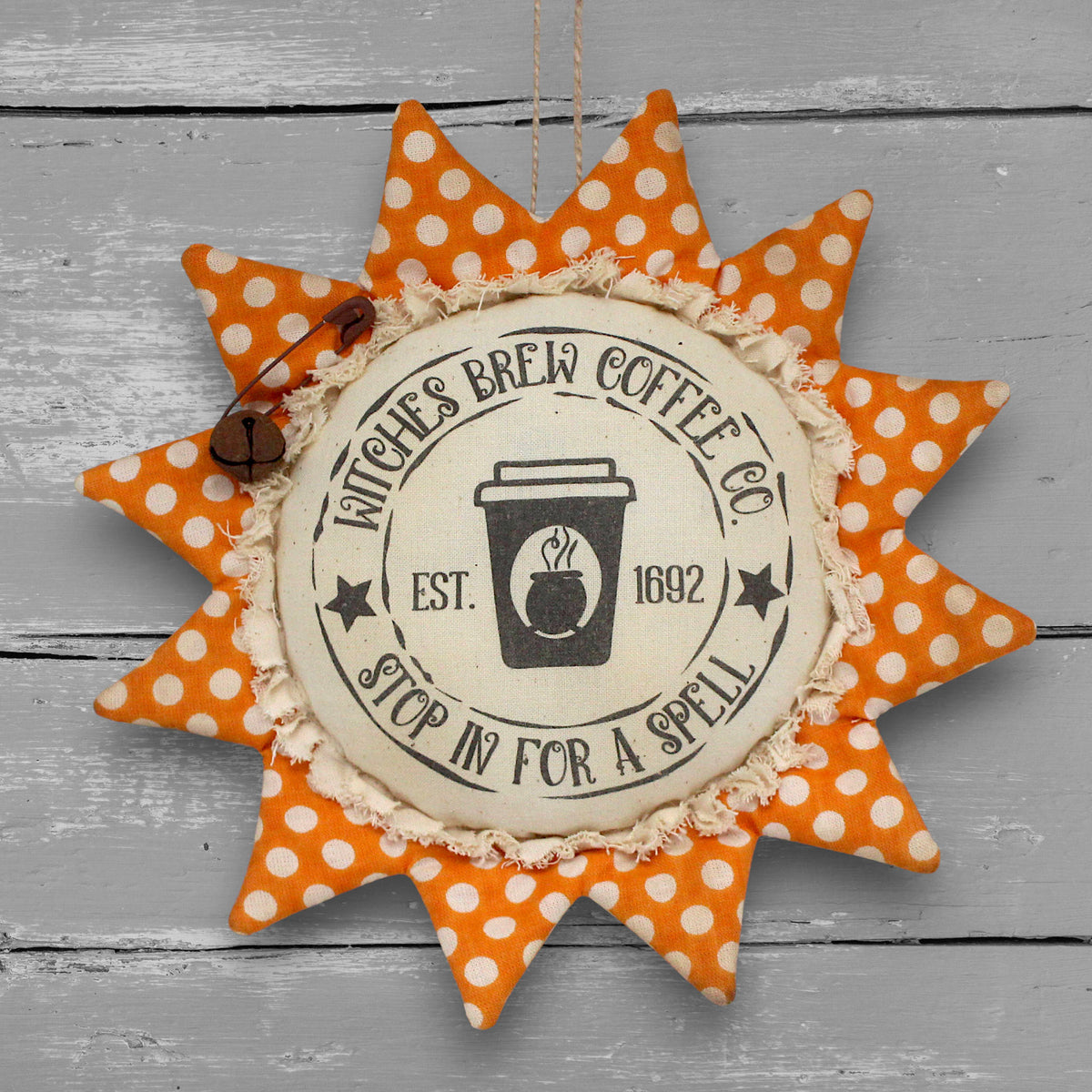 Primitive handmade fabric sunflower ornament for Halloween with a printed center that reads "Witches Brew Coffee Co. stop in for a spell."