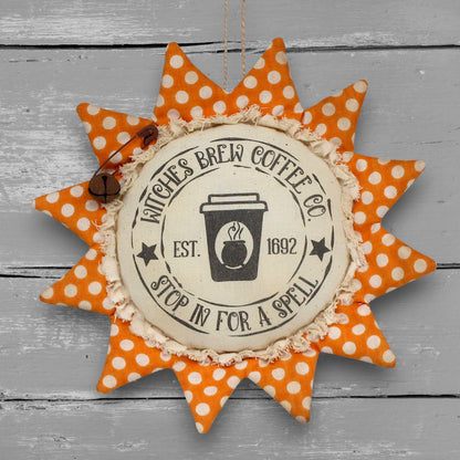 Primitive handmade fabric sunflower ornament for Halloween with a printed center that reads "Witches Brew Coffee Co. stop in for a spell."